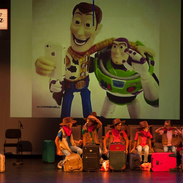 Foto d'un musical. Surten a l'escenari uns nens amb barrets de cowboy. Estan representant una escena de Toy Story.