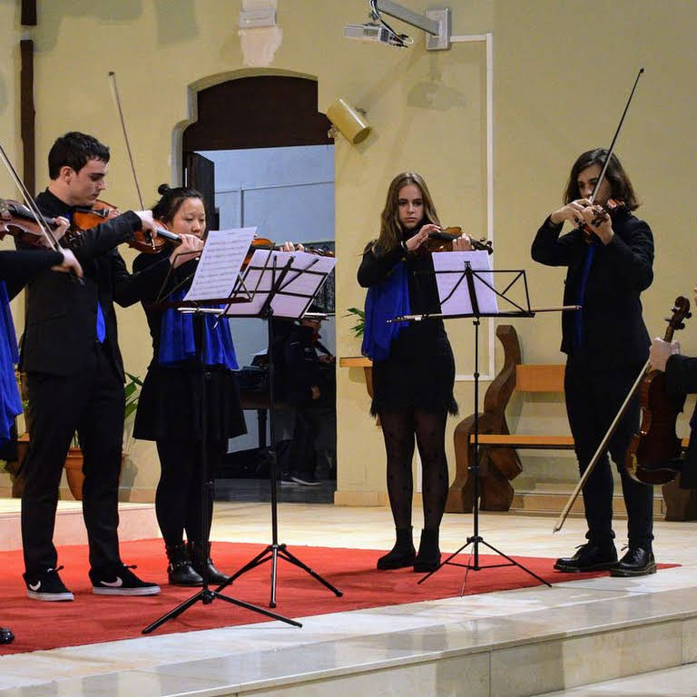 Foto d'un moment d'un concert a l'Esglèsia Major. Surten tocant violins.